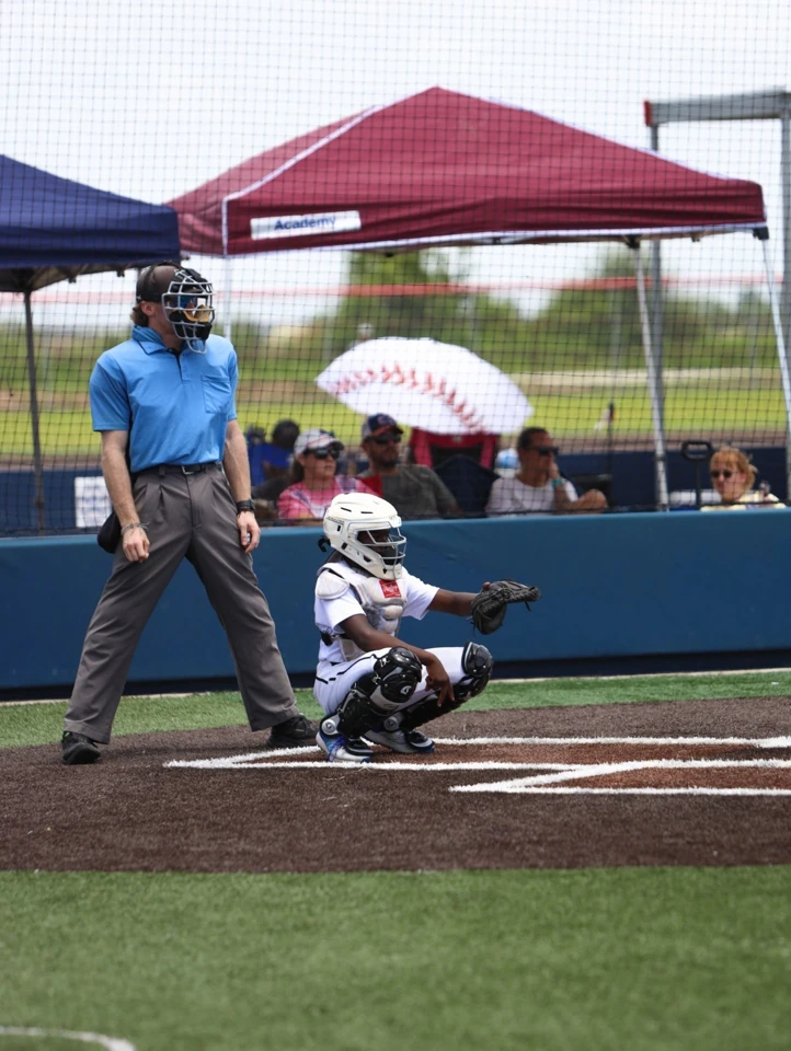 BBN Prospects catcher crouching in white protective gear with an umpire behind home plate