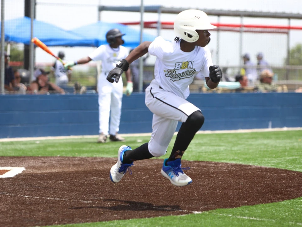 BBN Prospects baserunner in a white uniform and helmet sprinting on the basepaths