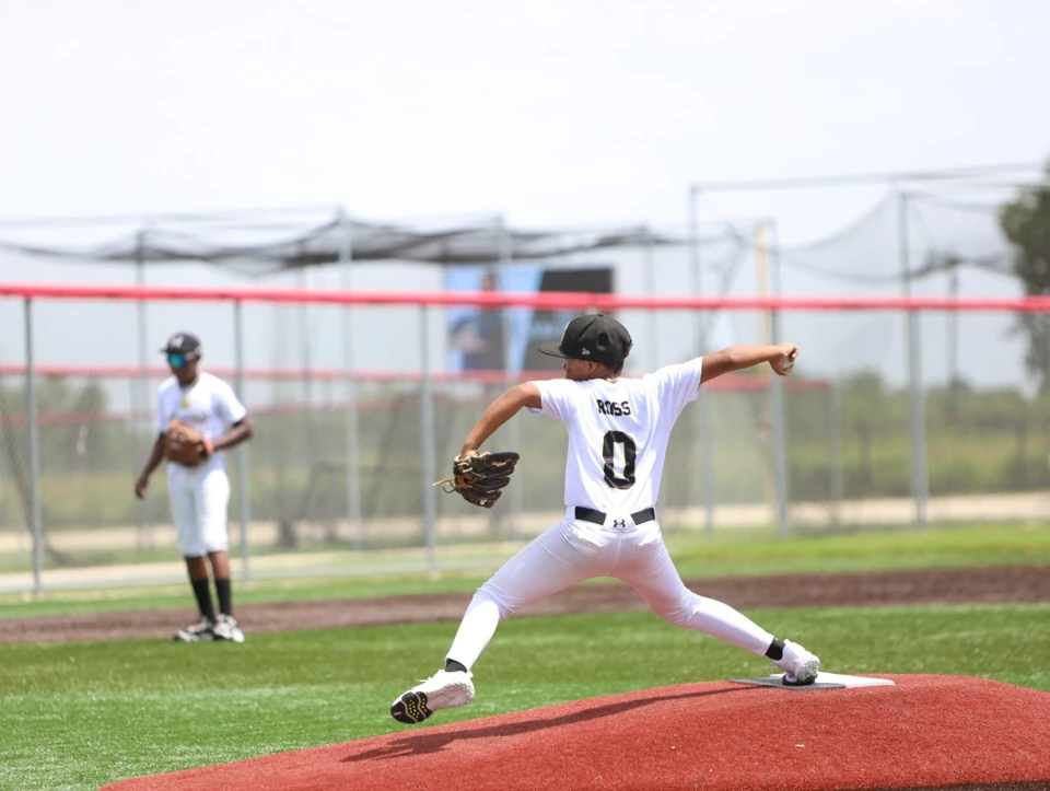 BBN Prospects pitcher in a white ROSS jersey delivering a pitch from the mound